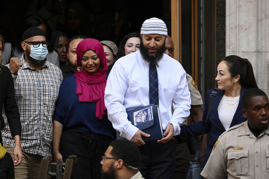 FILE - Adnan Syed, center right, leaves the courthouse after a hearing on Sept. 19, 2022, in Baltimore. An attorney requested a new hearing on Friday, Dec. 8, in a court proceeding that led to the release of Syed, who has been released from prison after his whose murder conviction chronicled in the hit podcast "Serial" already has been dismissed.