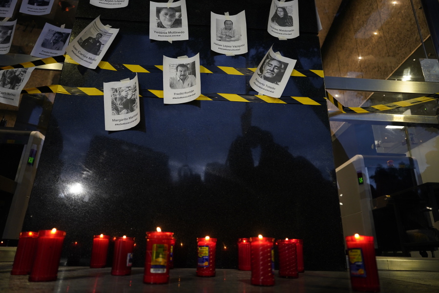 FILE - Photos of slain journalists are displayed on a wall during a vigil to protest the murder of journalist Fredid Roman, outside Mexico's Attorney General's office in Mexico City, Wednesday, Aug. 24, 2022. Roman was the 15th media worker killed so far this year in Mexico, where it is now considered the most dangerous country for reporters outside a war zone.