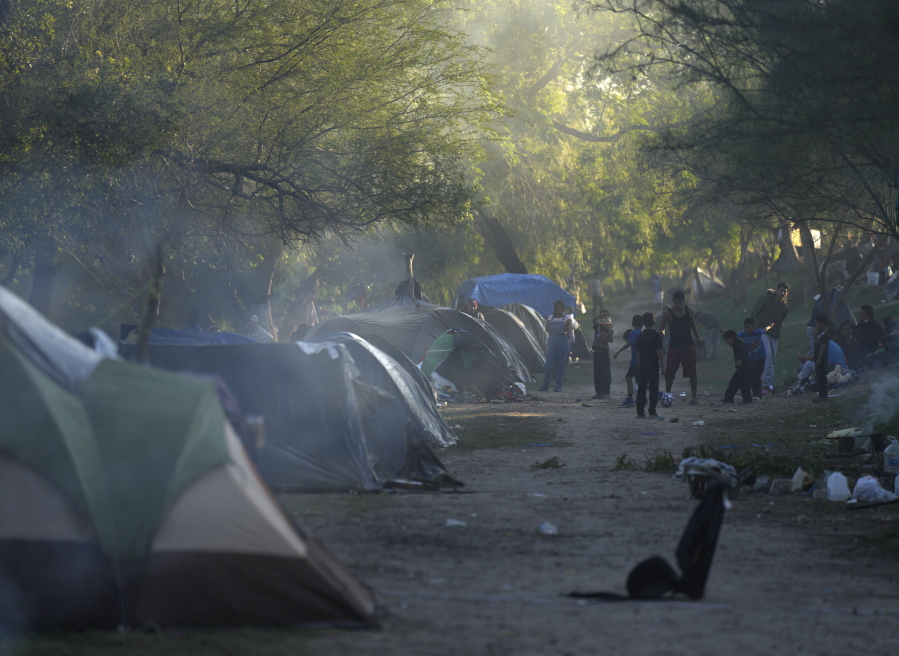 Venezuelan migrants play soccer at a makeshift campson a river bank in Matamoros, Mexico, Thursday, Dec. 22, 2022.
