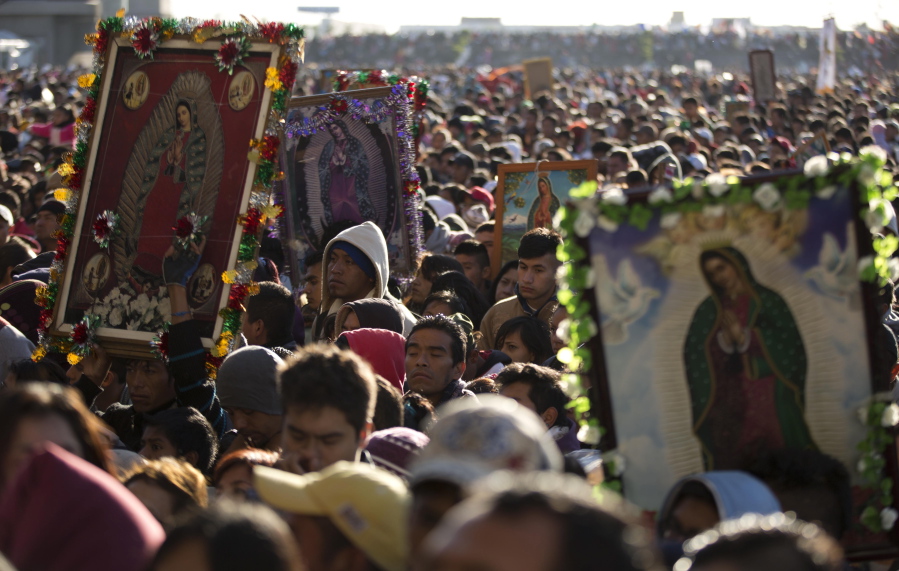 FILE - Pilgrims wait their turn to enter the Basilica of Guadalupe, in Mexico City, Dec. 12, 2013. Hundreds of thousands of people from all over the country converge on Mexico's holy Roman Catholic site, many bringing with them images or statues of Mexico's patron saint to be blessed, marking the Virgin's Dec. 12 feast day.