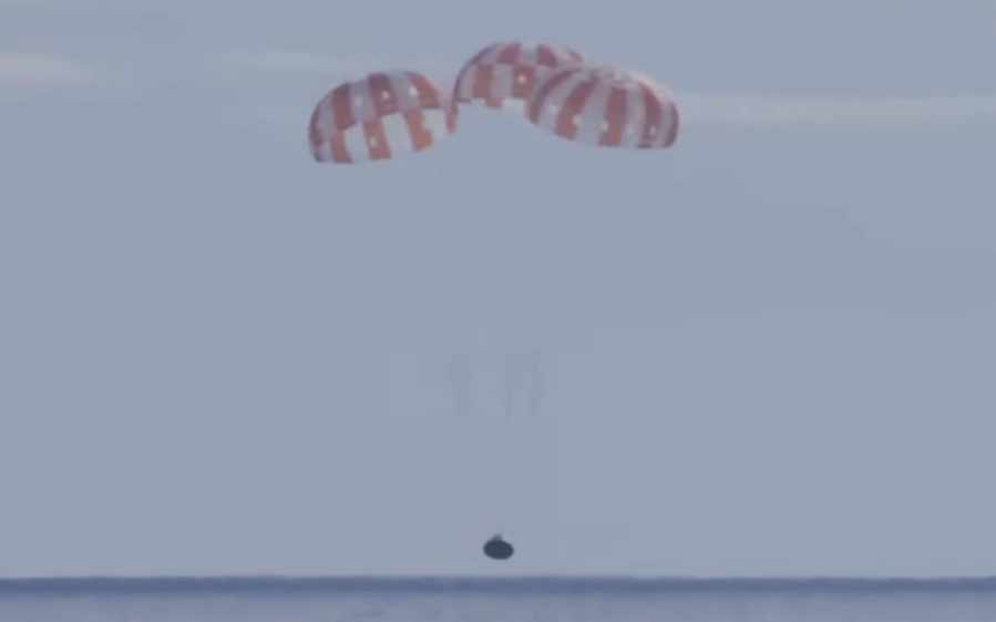This photo provided by NASA shows the Orion capsule coming back from the moon. The capsule made a blisteringly fast return Sunday, Dec. 11, 2022, parachuting into the Pacific off Mexico to conclude a dramatic 25-day test flight. The mission should clear the way for astronauts on the program's next lunar flyby, set for 2024.