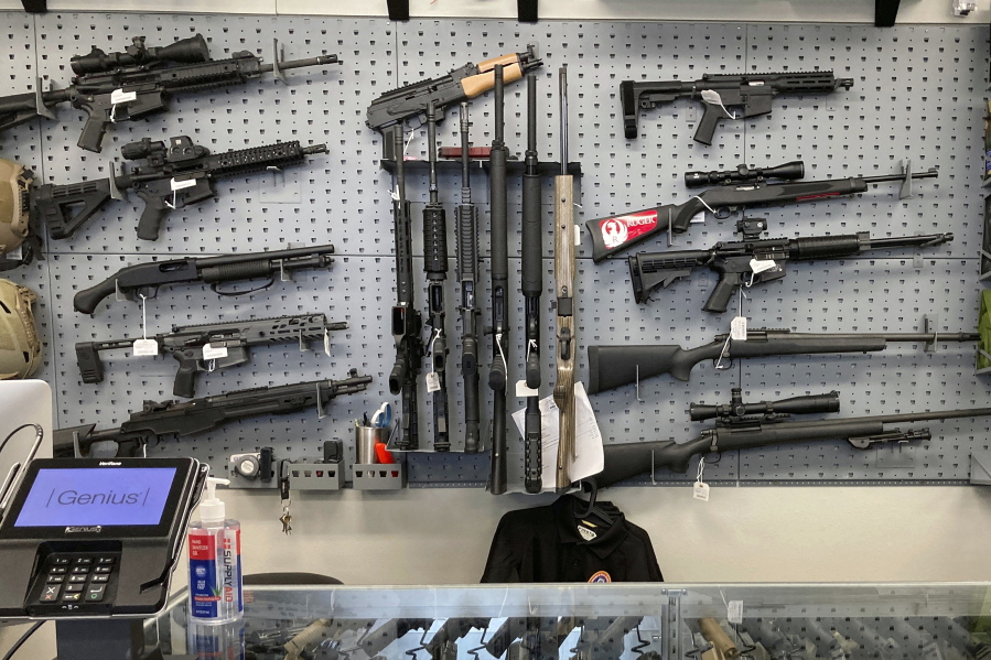 FILE - Firearms are displayed at a gun shop in Salem, Ore., on Feb. 19, 2021. An Oregon judge on Tuesday, Dec. 13, 2022, extended an earlier order blocking a key part of a new, voter-approved gun law and was hearing lengthy arguments on whether to also prevent the law's ban on high-capacity magazines from taking effect.