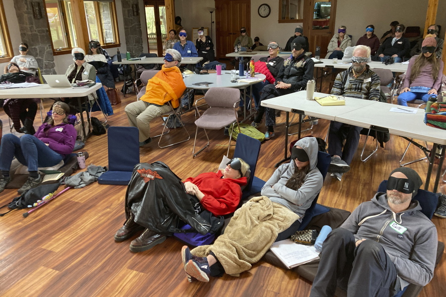 Psilocybin facilitator students sit with eye masks on while listening to music during an experiential activity at a training session near Damascus, Ore., on Dec. 2, 2022. They are being trained in how to accompany patients tripping on psilocybin as Oregon prepares to become the first state in America to offer controlled use of the psychedelic mushroom to the public.
