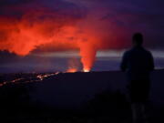 A man watches as lava erupts from Hawaii's Mauna Loa volcano Wednesday near Hilo, Hawaii.