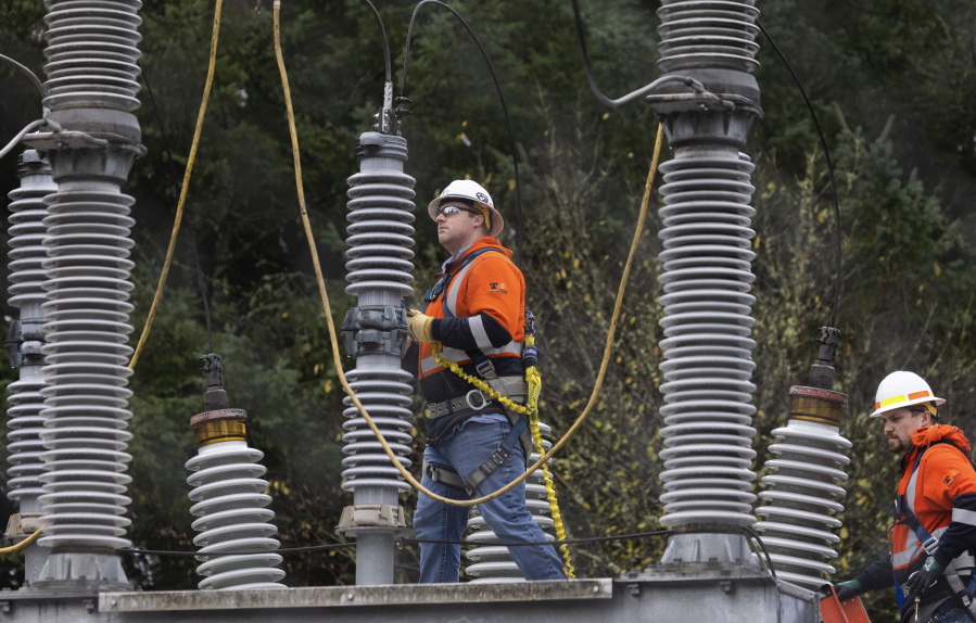 A Tacoma Power crew works at an electrical substation damaged by vandals early on Christmas morning, Sunday, Dec. 25, 2022, in Graham, Wa.