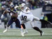 Seattle Seahawks running back Kenneth Walker III (9) runs past Las Vegas Raiders cornerback Rock Ya-Sin (26) and defensive end Maxx Crosby (98) during the first half of an NFL football game Sunday, Nov. 27, 2022, in Seattle.