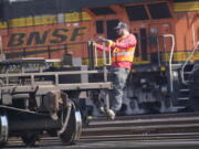 FILE - A worker rides a rail car at a BNSF rail crossing in Saginaw, Texas, Wednesday, Sept. 14, 2022. Most railroad workers weren't surprised that Congress intervened this week to block a railroad strike, but they were disappointed because they say the deals lawmakers imposed didn't do enough to address their quality of life concerns about demanding schedules and the lack of paid sick time.