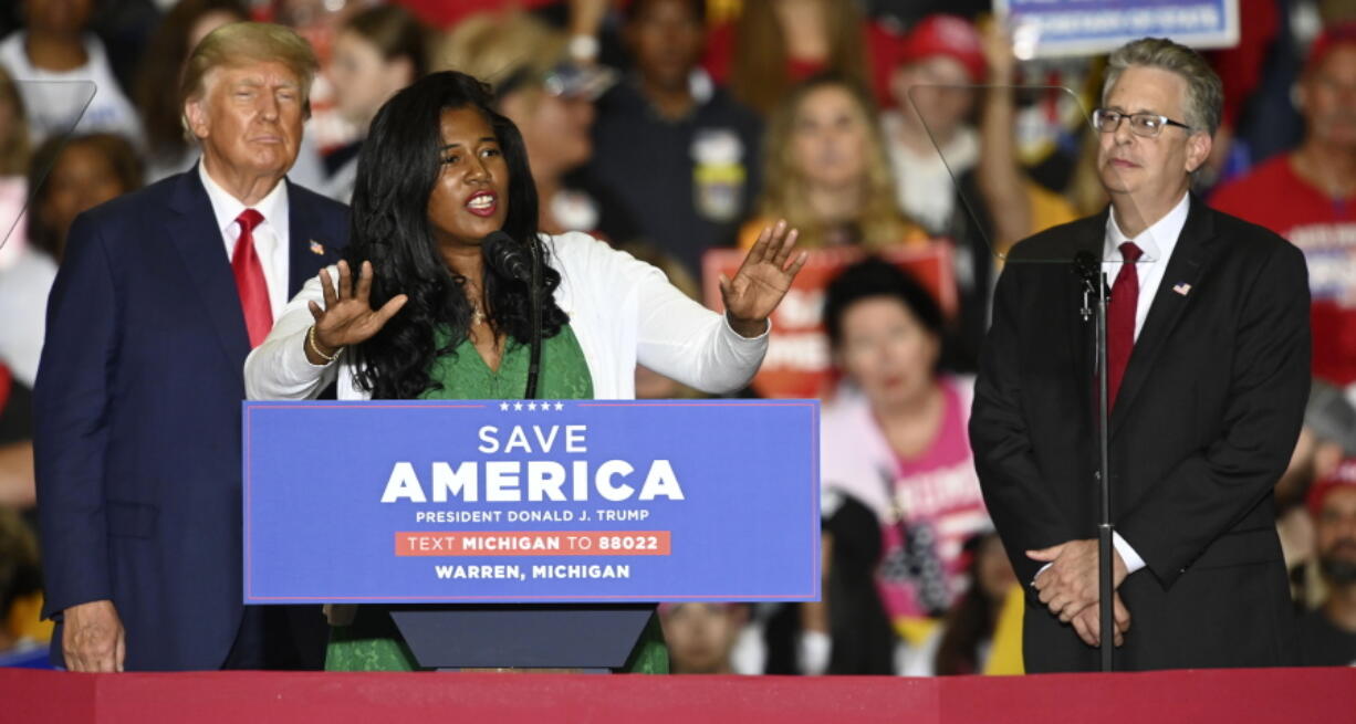FILE - Former President Donald Trump, left, and Michigan Republican attorney general candidate Matt DePerno, right, listen as Michigan Republican secretary of state candidate Kristina Karamo addresses the crowd during a rally at the Macomb Community College Sports & Expo Center in Warren, Mich., Saturday, Oct. 1, 2022. Karamo, a community college instructor, ran as a far-right candidate in the 2022 midterms after becoming one of the most prominent election conspiracists in the country.