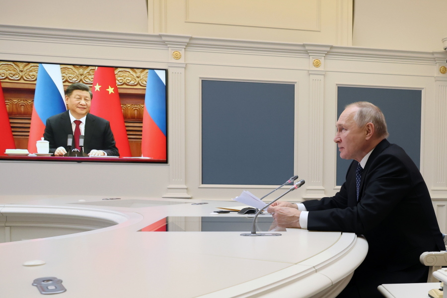 Russian President Vladimir Putin speaks during a meeting with Chinese President Xi Jinping, seen onscreen,  via  a video conference at the Kremlin in Moscow, Russia, Friday, Dec. 30, 2022.