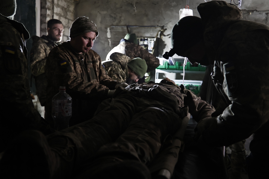 Ukrainian servicemen give the first aid to a soldier wounded in a battle with the Russian troops in their shelter in the Donetsk region, Ukraine, Thursday, Dec. 1, 2022. A top adviser to Ukraine's president has cited military chiefs as saying 10,000 to 13,000 Ukrainian soldiers have been killed in the country's nine-month struggle against Russia's invasion, a rare comment on such figures and far below estimates of Ukrainian casualties from Western leaders. Late Thursday, Dec.