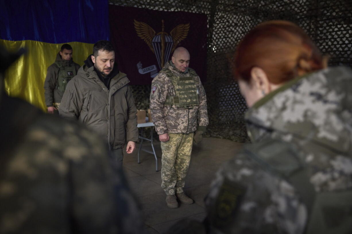 In this photo provided by the Ukrainian Presidential Press Office, Ukrainian President Volodymyr Zelenskyy, centre left, stands along servicemen during a minute of silence in honor of soldiers killed during fighting with Russian troops as he visits the Sloviansk, Donbas region, Ukraine, Tuesday, Dec. 6, 2022.