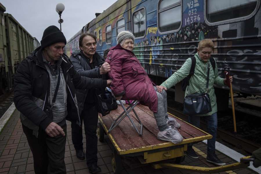 Relatives of Elizaveta, 94, transport her by a cargo cart to the evacuation train in Kherson, Ukraine, Thursday, Dec. 1, 2022.