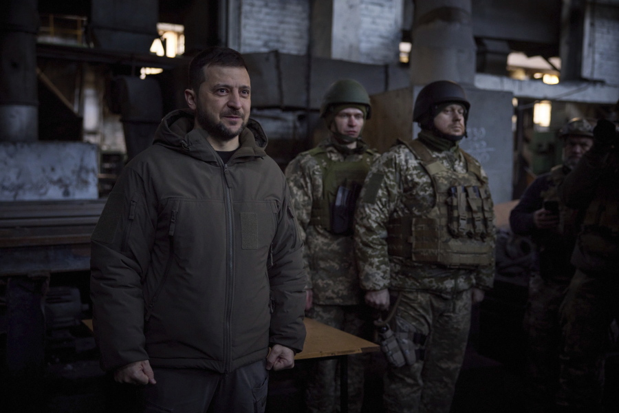 In this photo provided by the Ukrainian Presidential Press Office, Ukrainian President Volodymyr Zelenskyy, left, speaks to soldiers at the site of the heaviest battles with the Russian invaders in Bakhmut, Ukraine, Tuesday, Dec. 20, 2022.