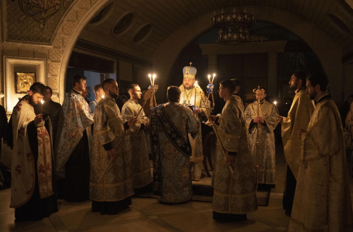 Metropolitan Oleksandr delivers a religious service with clerics inside the Transfiguration of Jesus Orthodox Cathedral during blackout caused by recent Russian rocket attacks, in Kyiv, Ukraine, Saturday, Dec. 3, 2022. A top Orthodox priest in Ukraine's capital says he supports the efforts of President Volodymyr Zelenskyy's government and counter-intelligence agency to end Russian spying and meddling in Ukrainian politics through a Moscow-affiliated church.