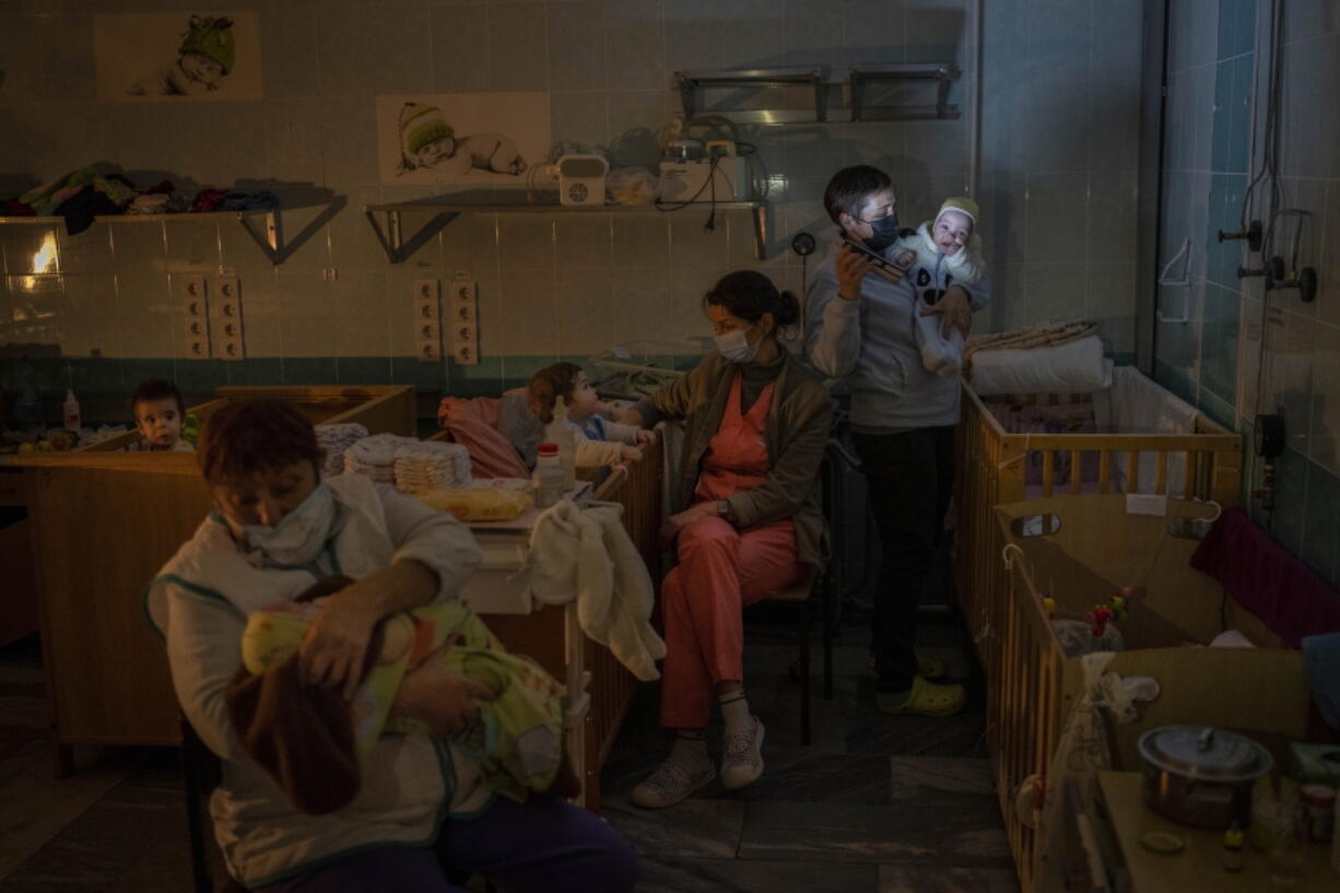 Hospital staff take care of orphaned children at the children's regional hospital maternity ward in Kherson, southern Ukraine, Tuesday, Nov. 22, 2022.  Throughout the war in Ukraine, Russian authorities have been accused of deporting Ukrainian children to Russia or Russian-held territories to raise them as their own. At least 1,000 children were seized from schools and orphanages in the Kherson region during Russia's eight-month occupation of the area, their whereabouts still unknown.