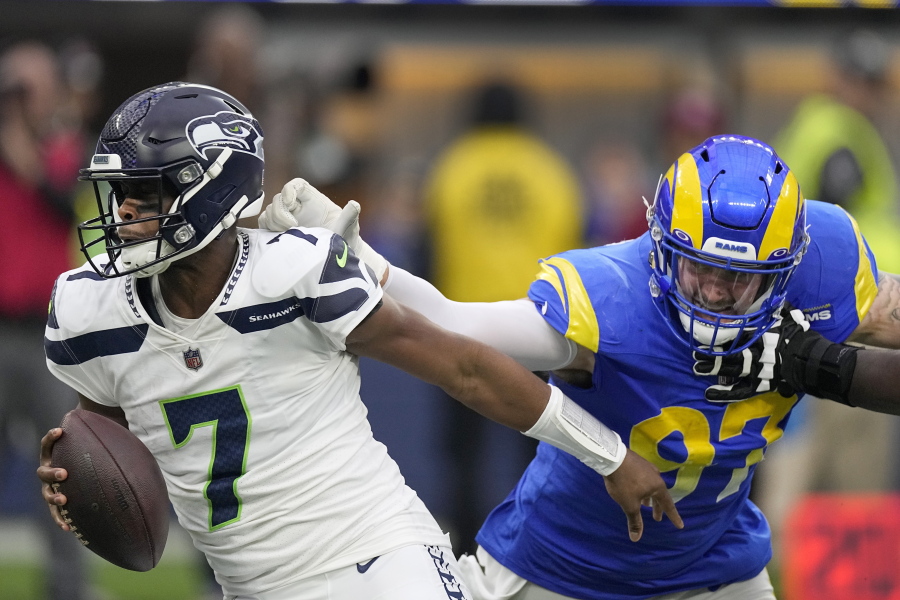 Los Angeles Rams defensive tackle Michael Hoecht (97) sacks Seattle Seahawks quarterback Geno Smith (7) during the first half of an NFL football game Sunday, Dec. 4, 2022, in Inglewood, Calif. (AP Photo/Mark J.