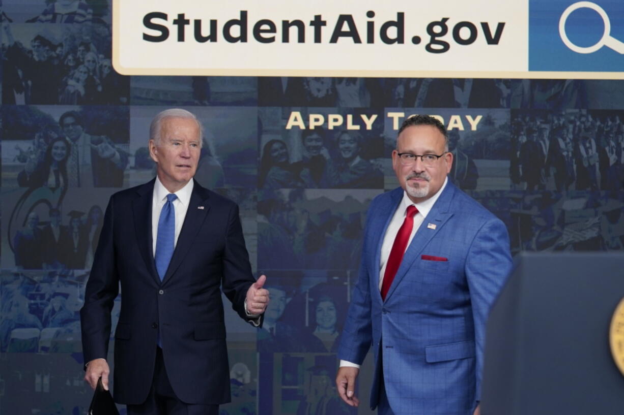 FILE - President Joe Biden answers questions with Education Secretary Miguel Cardona as they leave an event about the student debt relief portal beta test in the South Court Auditorium on the White House complex in Washington, Oct. 17, 2022. The Biden administration is no longer accepting applications for student loan forgiveness after a second federal court shut down the program.