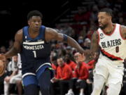 Minnesota Timberwolves guard Anthony Edwards, left, brings the ball up the court on Portland Trail Blazers guard Damian Lillard, right, during the first half of an NBA basketball game in Portland, Ore., Monday, Dec. 12, 2022.