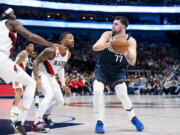 Dallas Mavericks guard Luka Doncic (77) looks to pass the ball as Portland Trail Blazers guard Damian Lillard (0) defends against him in the first half of an NBA basketball game in Dallas, Friday, Dec. 16, 2022.