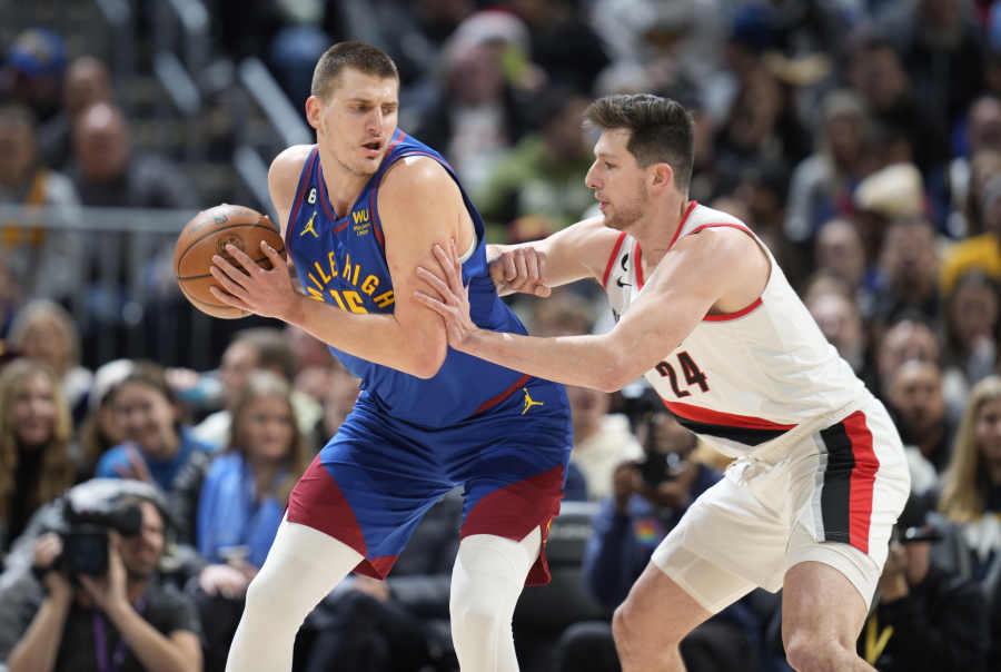 Denver Nuggets center Nikola Jokic, left, looks to drive to the rim as Portland Trail Blazers forward Drew Eubanks defends in the first half of an NBA basketball game Friday, Dec. 23, 2022, in Denver.