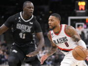 Portland Trail Blazers' Damian Lillard (0) drives against San Antonio Spurs' Gorgui Dieng during the first half of an NBA basketball game, Wednesday, Dec. 14, 2022, in San Antonio.