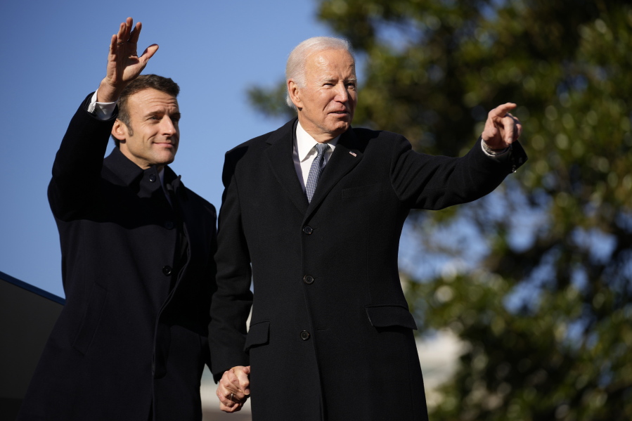 President Joe Biden and French President Emmanuel Macron stand on the stage during a State Arrival Ceremony on the South Lawn of the White House in Washington, Thursday, Dec. 1, 2022.