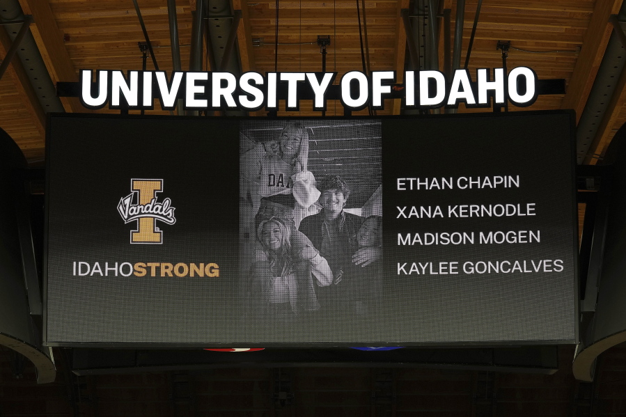 FILE - A photo and the names of four University of Idaho students who were killed over the weekend at a residence near campus are displayed during a moment of silence, Nov. 16, 2022, before an NCAA college basketball game in Moscow, Idaho. Investigators have yet to name a suspect in the stabbing deaths of four University of Idaho students who were found dead in a home near campus last month. But would-be armchair detectives and internet sleuths have come up with several of their own, the conclusions often based on conjecture and rumor. (AP Photo/Ted S.