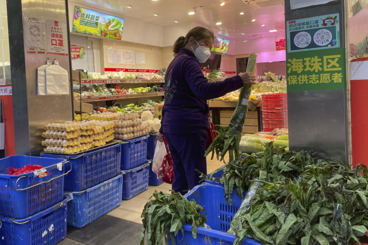 A woman shops in a reopened grocery store in the district of Haizhu as pandemic restrictions are eased in southern China's Guangzhou province, Thursday, Dec. 1, 2022. More Chinese cities eased some anti-virus restrictions as police patrolled their streets to head off protests Thursday while the ruling Communist Party prepared for the high-profile funeral of late leader Jiang Zemin.