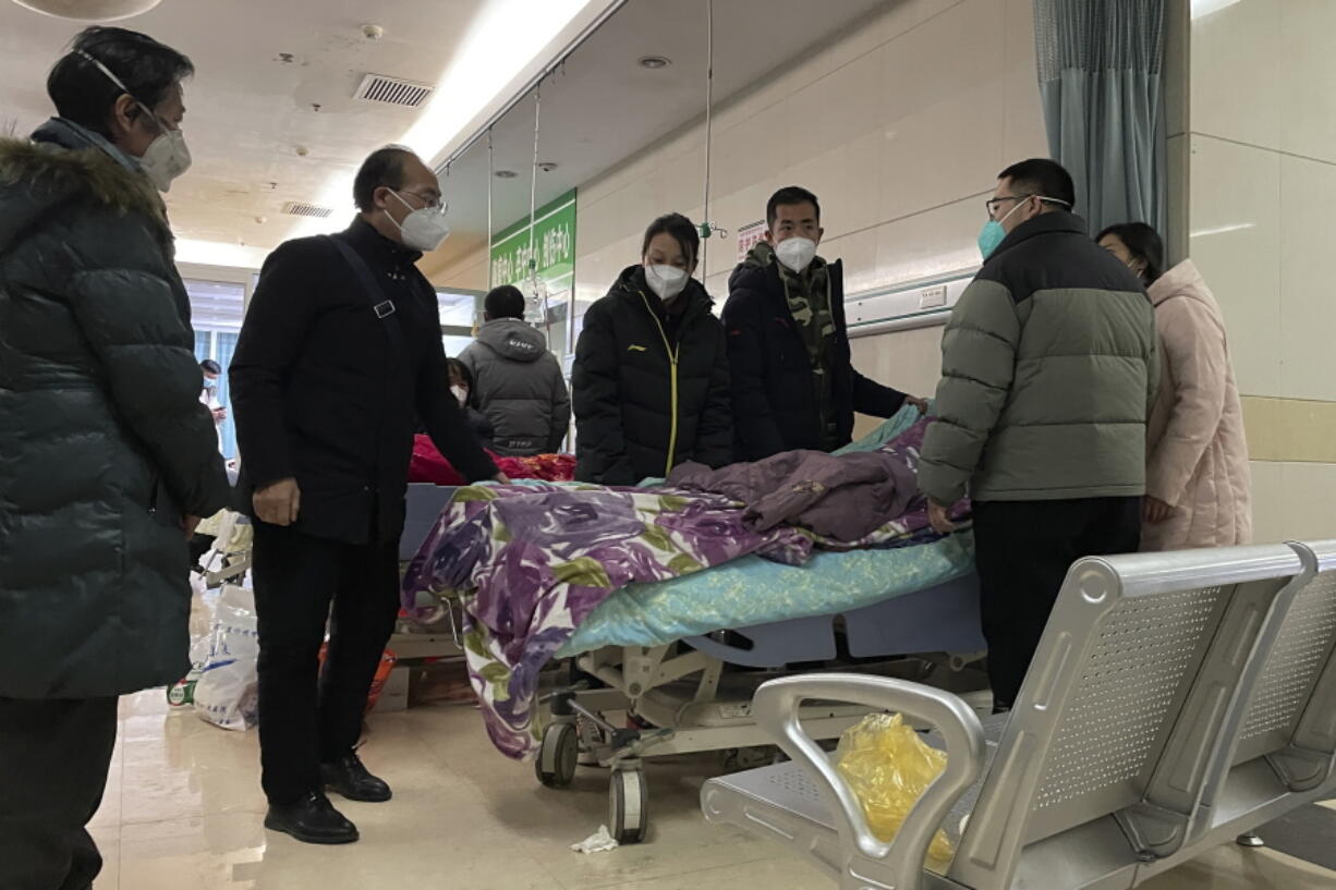A man pulls a cloth to cover up the face of an elderly woman whose vitals flatlined as emotional relatives gather silently around her for a final farewell before her body is taken away at the emergency department of the Langfang No. 4 People's Hospital in Bazhou city in northern China's Hebei province on Thursday, Dec. 22, 2022. As China grapples with its first-ever wave of COVID mass infections, emergency wards in the towns and cities to Beijing's southwest are overwhelmed. Intensive care units are turning away ambulances, residents are driving sick relatives from hospital to hospital, and patients are lying on floors for a lack of space.