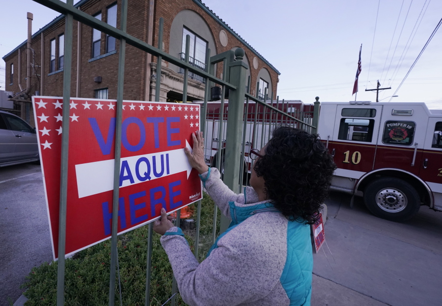 FILE - Election worker Ramona Ortiz places a sign outside a polling station at Fire Station 3 on E. Rio Grande Ave in El Paso, Texas, just before polls open on Nov. 8, 2022. Next year is shaping up to be another busy for state legislatures seeking to change voting laws.