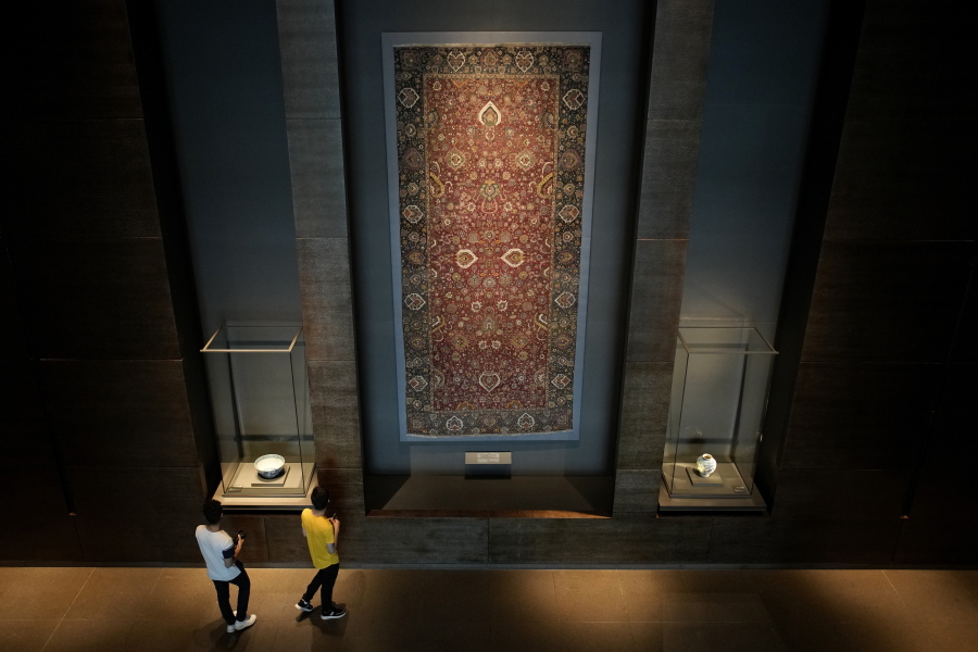 Visitors view an Iranian carpet at the Museum of Islamic Art in Doha, Qatar, Tuesday, Nov. 22, 2022.