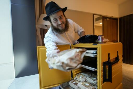 Eli Chitrik from Turkey shows bagel sandwiches in his hotel room in Doha, Qatar, on Monday.