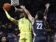 Oregon guard Rivaldo Soares (11) shoots against Washington State guard Dylan Darling (22) during the first half of an NCAA college basketball game in Eugene, Ore., Thursday, Dec. 1, 2022.