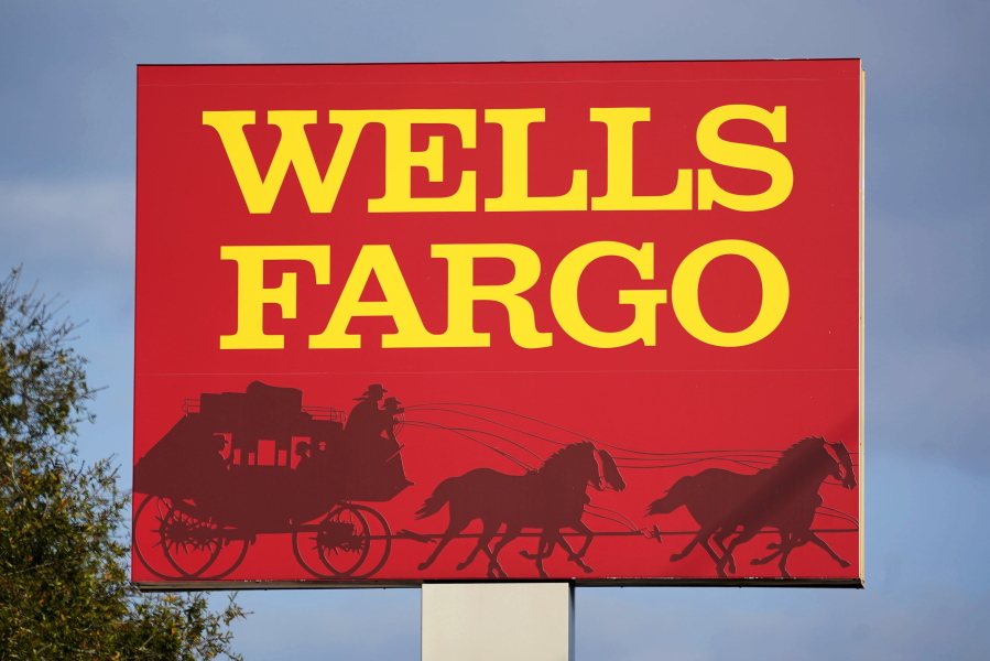 FILE - A Wells Fargo sign stands in front of a branch of the bank in Bradenton, Fla., Tuesday, Feb. 22, 2022. Consumer banking giant Wells Fargo is being ordered to pay $3.7 billion in fines and refunds to customers by U.S. government regulators, the largest fine to date against the bank. (AP Photo/Gene J.