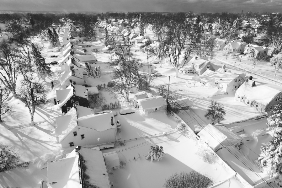 In this drone image, snow blankets a neighborhood, Sunday, Dec. 25, 2022, in Cheektowaga, N.Y.