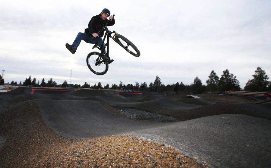Brandon Giessinger, of Bend, launches a one-footed air over a gap while riding on the bike pump track at Big Sky Sports Park in Bend, Oregon.