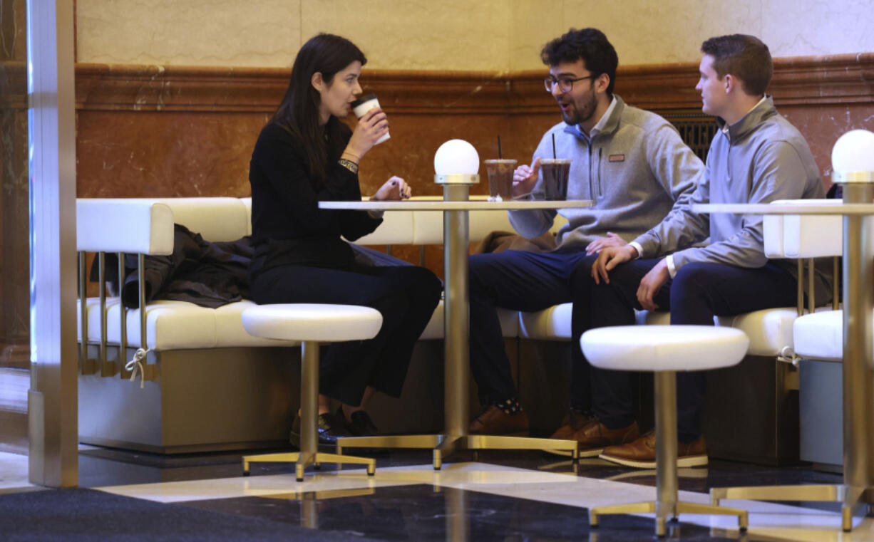 Co-workers Victoria Willard, from left, Daniel Poncer, and Jack Wells talk over hot drinks at West Town Bakery, inside 190 S. LaSalle St., in Chicago, on Jan. 5, 2023.