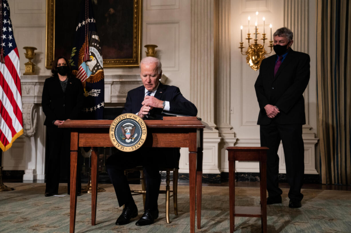 President Joe Biden signs executive orders after speaking about climate change issues in the State Dining Room of the White House on Jan. 27, 2021, in Washington, D.C.