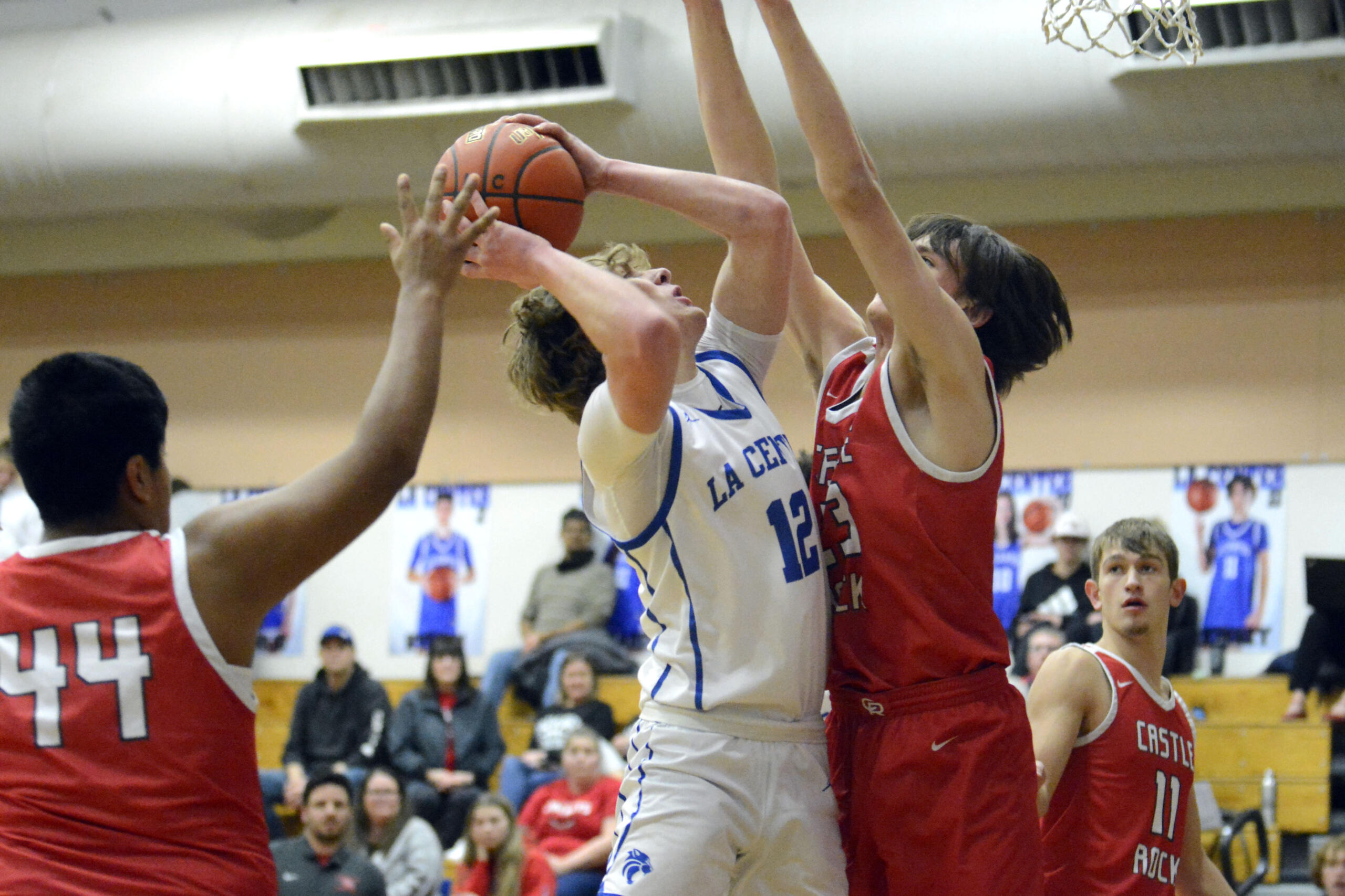 La Center’s Austin Nixon (12) looks to go up for a shot over Castle Rock’s James Montgomery (23) in a Trico League boys basketball game on Wednesday, Jan. 18, 2023, at La Center High School.