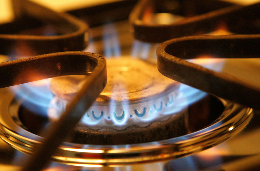 A burner on a stove emits blue flames from natural gas in Des Plaines, Ill. Gas stoves are taking heat from environmental groups and government agencies.