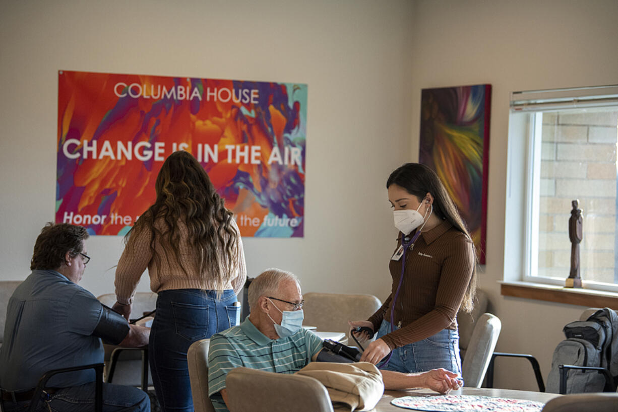 Columbia House resident Jerrol Stanley, from left, has his blood pressure checked by nursing student Olivia Spitzer as fellow resident Billy Davidson also gets checked by nursing student Venetia Prontzos.