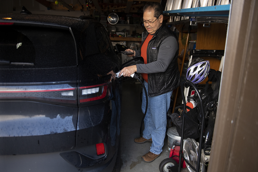 Phil Hays of Salmon Creek demonstrates how he charges his 2023 Volkswagen ID.4 electric vehicle. Hays had to regroup after one dealership slapped a $7,500 mark-up on an ID.4 he'd ordered months before.