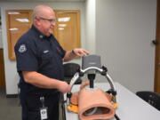Clark County Fire District 6 EMS Training Captain, Eric Simukka, demonstrates on a mannequin how the LUCAS device works to perform CPR.