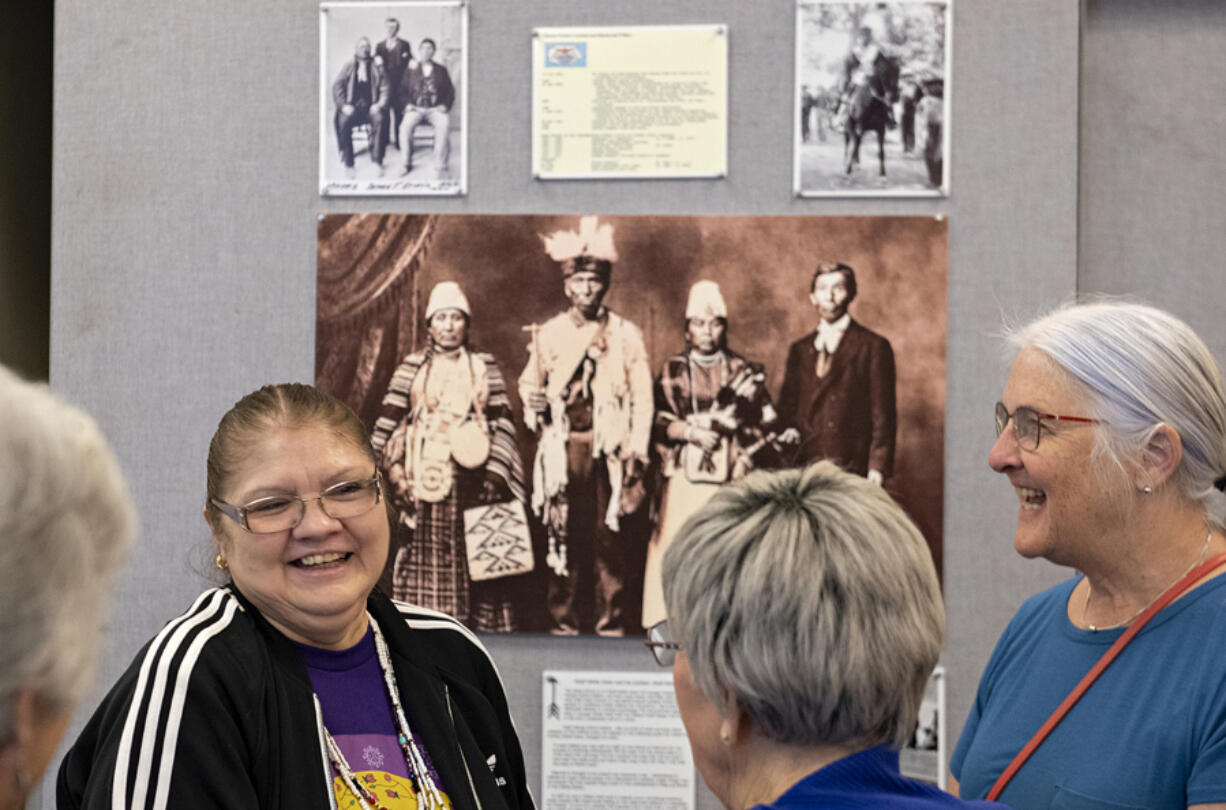 Mary Umtuch, left, descendent of Chief Umtuch, chats with visitors at Battle Ground Community Library including Bev Jones of Battle Ground, right, as they check out an exhibit featuring some of Battle Ground's Native American history Thursday.