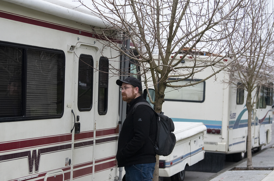 Cody Shaw of the Council for the Homeless knocks on the door of a recreational vehicle parked along Fort Vancouver Way while helping with the Point in Time Count on Thursday morning. Point in Time is an annual count of people experiencing homelessness, which feeds the yearly report.