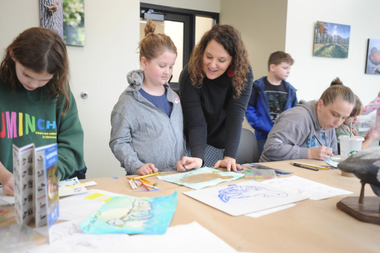 Art teacher Michelle Hankins, standing at right, helps her daughter Ruby decide what colors would best complement her duck drawing during a Saturday art workshop at the Ridgefield National Wildlife Refuge.