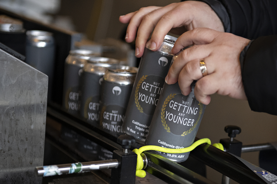 Michael Perozzo of Vice Beer lends a hand as cans of "Not Getting Any Younger" are packaged on Wednesday morning. Grocery store sales can be risky for craft brewers, since locked in prices leave no opportunity to make adjustments for increasing costs, eating into an already small profit margin.