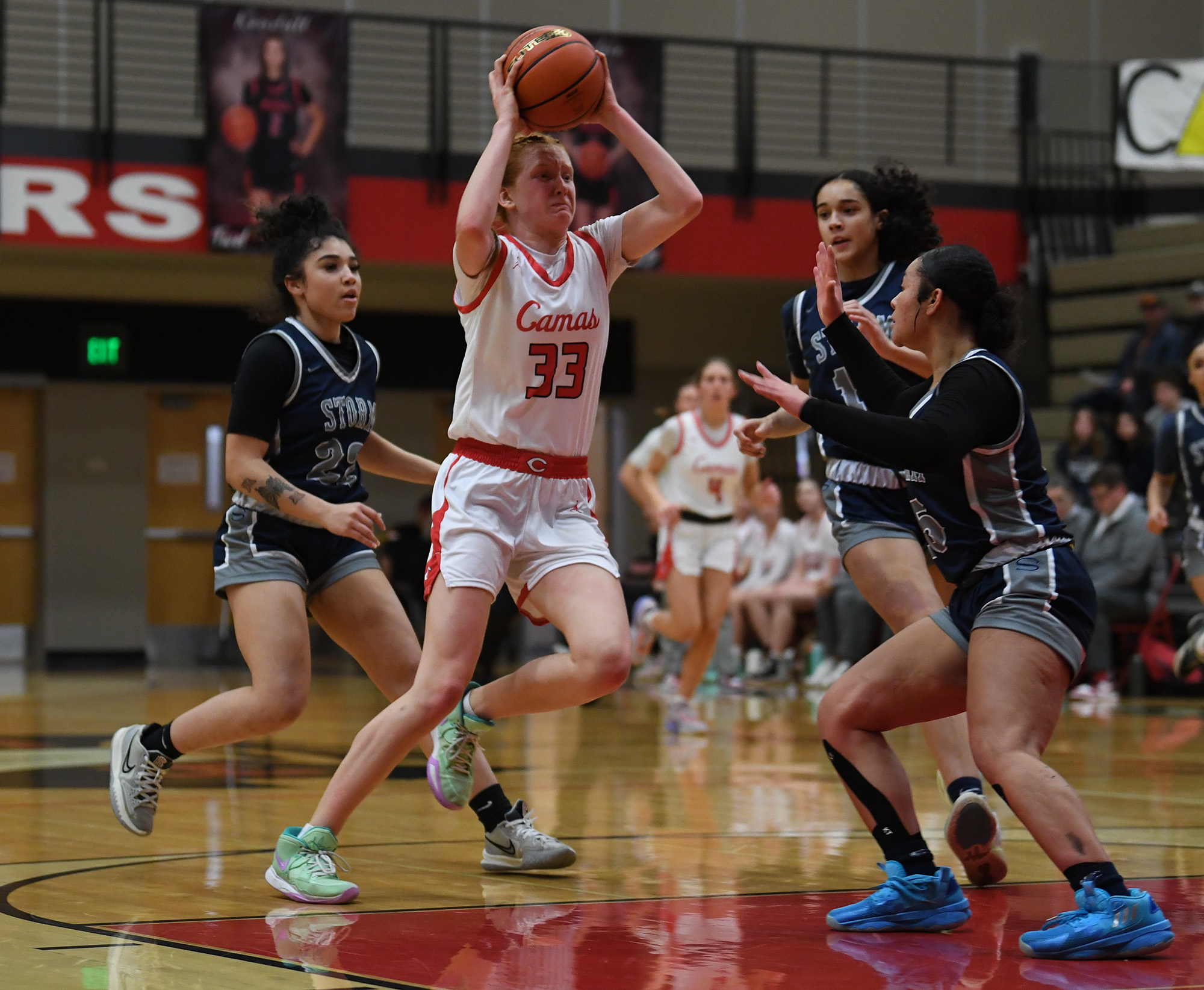 Camas junior Addison Harris, center, weaves between Skyview defenders Tuesday, Jan. 31, 2023, during the Papermakers’ 77-34 win against Skyview at Camas High School.