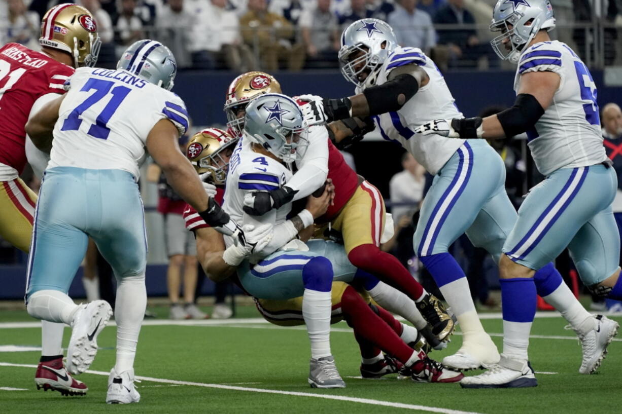 FILE -Dallas Cowboys quarterback Dak Prescott (4) is sacked by San Francisco 49ers defensive end Nick Bosa, center left rear, with help in the first half of an NFL wild-card playoff football game in Arlington, Texas, Sunday, Jan. 16, 2022. The 49ers-Cowboys playoff history is a rich one from back-to-back conference title games in the early 1970s, the iconic '??Catch'?? in the 1981 season and then the heated rivalry in the 1990s when the Cowboys won the first two meetings on the way to Super Bowl titles and then the Niners took the third game.