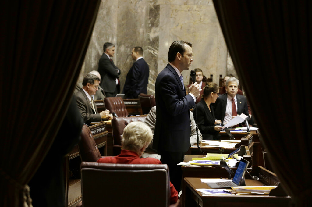 Sen. Andy Billig, D-Spokane, is seen through curtains of the wings as he speaks on the Senate floor at the Capitol in Olympia. (AP Photo/Ted S.